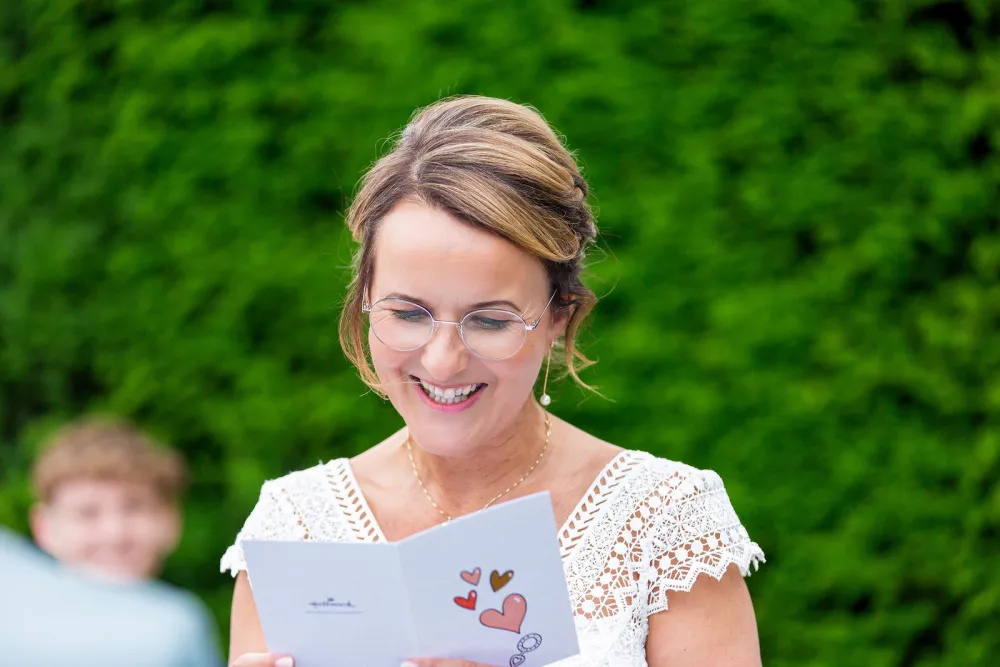 Lachende vrouw leest een kaart tijdens de ceremonie