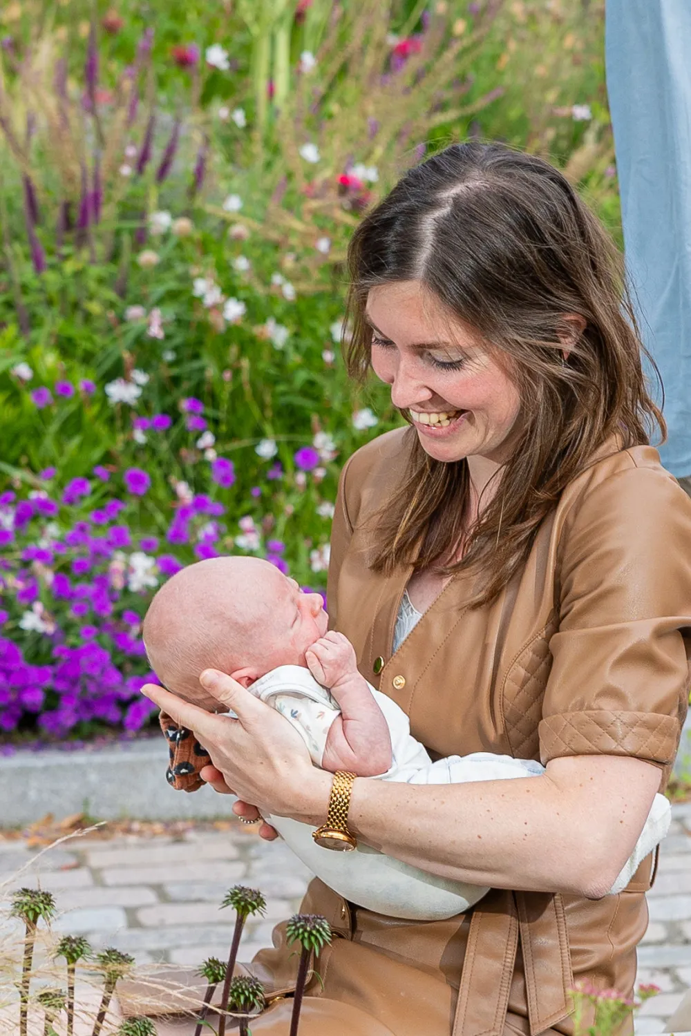 Moeder houdt haar baby vast in een bloementuin